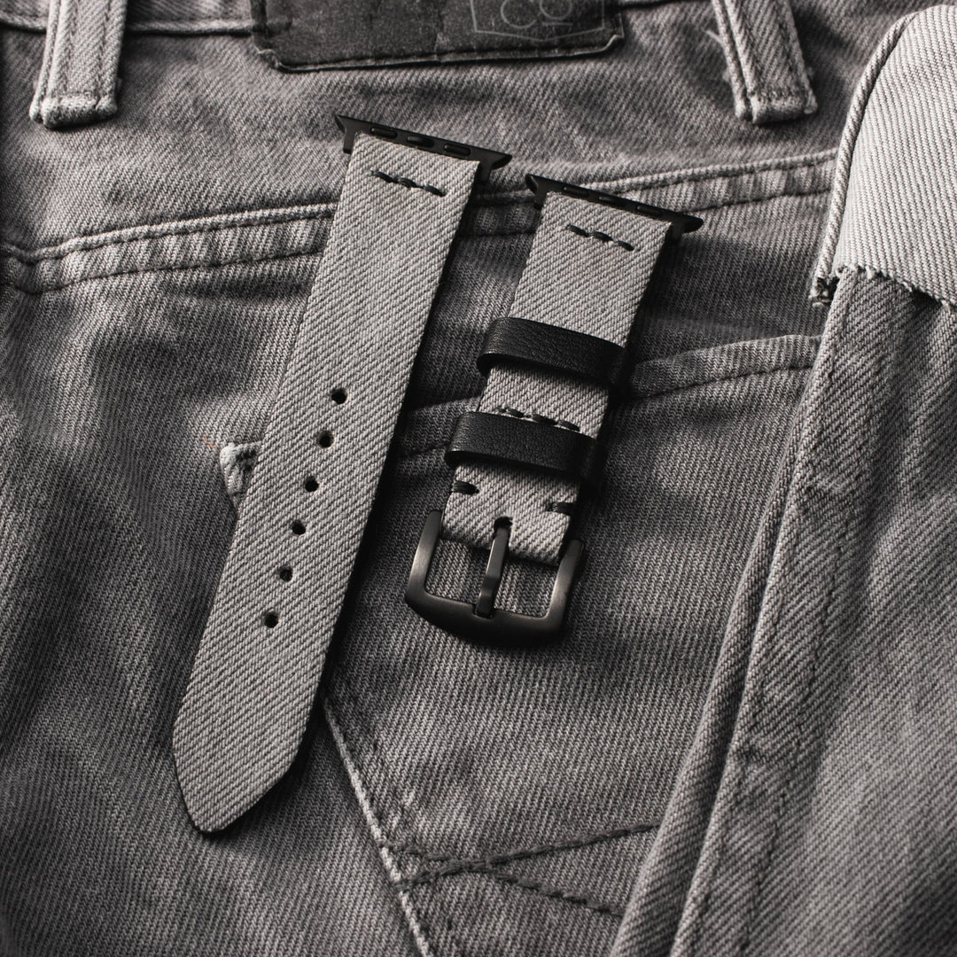 Roarstraps Apple Watch kot saat kayışı, gri denim kumaşın üzerinde şık bir görünüm sunuyor