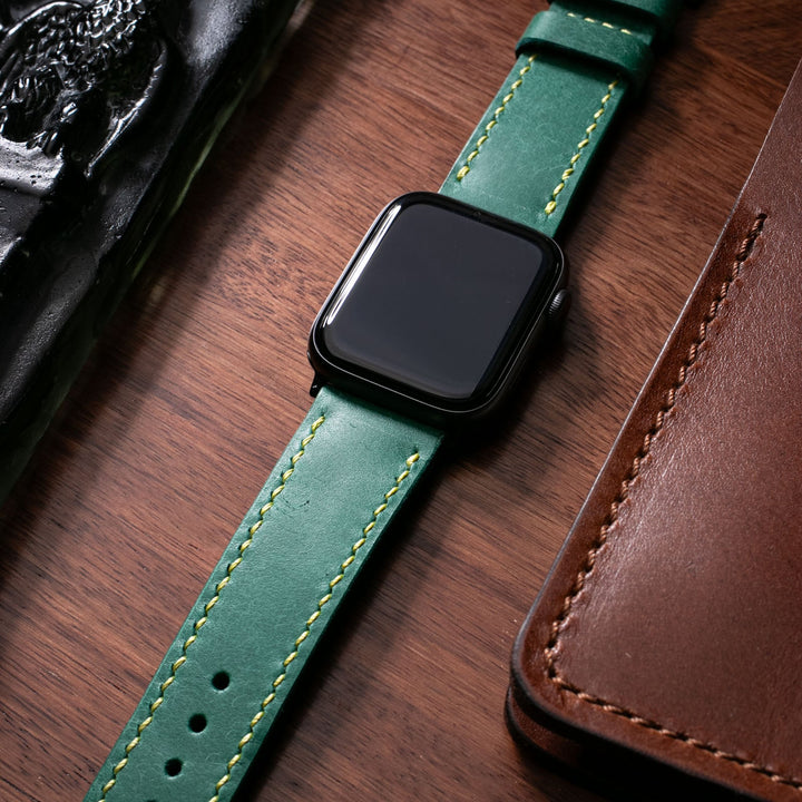 Roarstraps el yapımı Apple Watch deri kayışı, yeşil renk ve sarı dikiş detaylarıyla şık bir görünüm sunuyor.