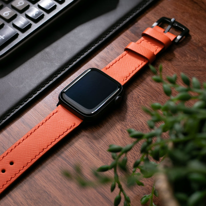 Saffiano turuncu deri Apple Watch kayış, şık tasarımıyla ofis masasında